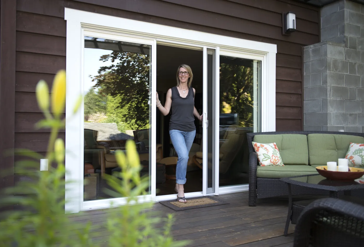 A retractable insect screen at a white aluminium sliding patio doorway.